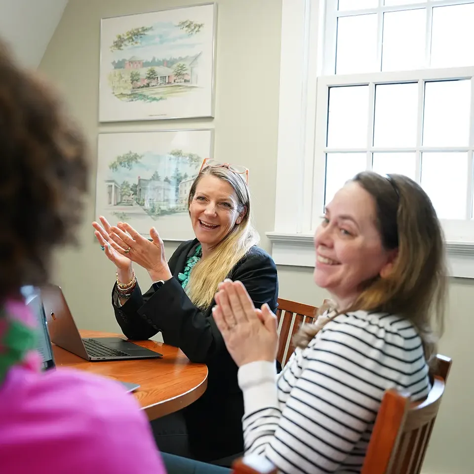 independent school consultant talking animatedly with clients around a large table